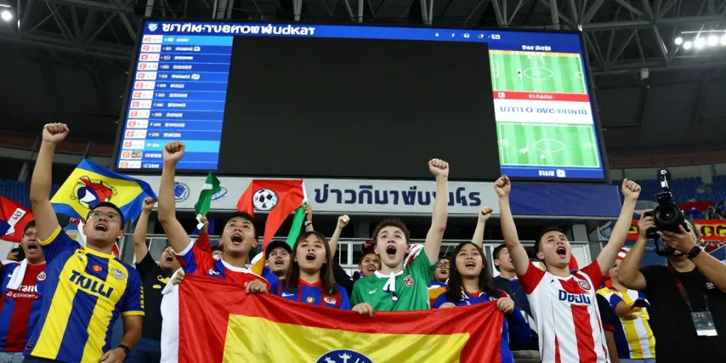 Excited football fans at a stadium cheering for their team during a live transfer update event on ข่าวกีฬาฟุตบอล.